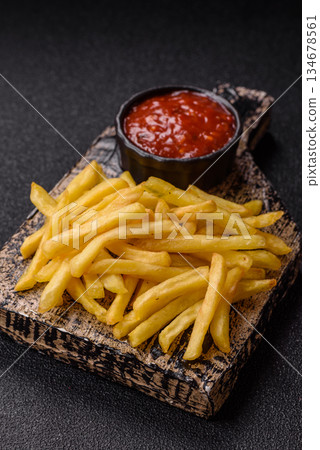 French fries cooked in oil, crispy golden chips, unhealthy food. French fries as a background French fries cooked in oil, crispy golden chips, unhealthy food. French fries as a background 134678561
