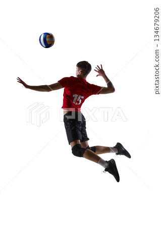 Volleyball player jumping and hitting ball isolated on white background. 134679206