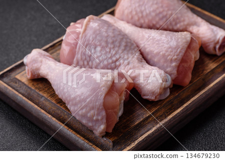 Raw chicken legs, poultry meat on the bone for barbecue. Chicken legs as a food background 134679230