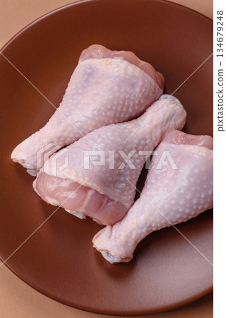 Raw chicken legs, poultry meat on the bone for barbecue. Chicken legs as a food background Raw chicken legs, poultry meat on the bone for barbecue. Chicken legs as a food background 134679248