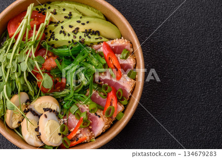 Seared tuna tataki in a bowl with sesame seeds, rice, and vegetables. Tuna tataki 134679283