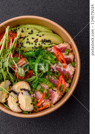 Seared tuna tataki in a bowl with sesame seeds, rice, and vegetables. Tuna tataki 134679284