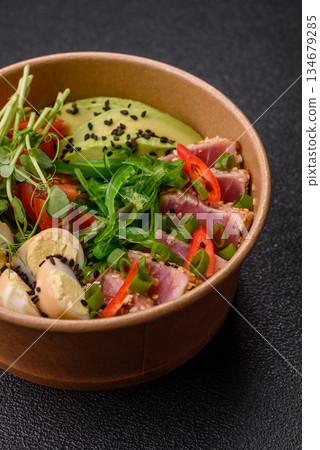 Seared tuna tataki in a bowl with sesame seeds, rice, and vegetables. Tuna tataki 134679285