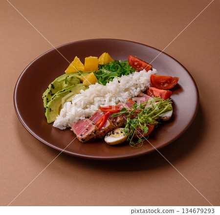 Seared tuna tataki in a bowl with sesame seeds, rice, and vegetables. Tuna tataki Seared tuna tataki in a bowl with sesame seeds, rice, and vegetables. Tuna tataki 134679293