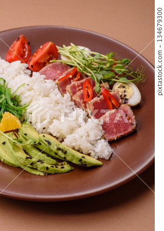 Seared tuna tataki in a bowl with sesame seeds, rice, and vegetables. Tuna tataki Seared tuna tataki in a bowl with sesame seeds, rice, and vegetables. Tuna tataki 134679300