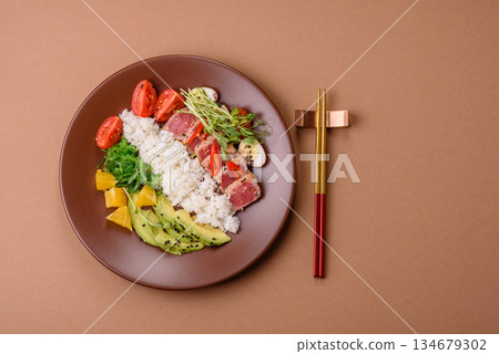 Seared tuna tataki in a bowl with sesame seeds, rice, and vegetables. Tuna tataki 134679302