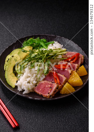 Seared tuna tataki in a bowl with sesame seeds, rice, and vegetables. Tuna tataki 134679312