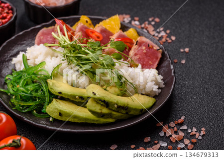 Seared tuna tataki in a bowl with sesame seeds, rice, and vegetables. Tuna tataki Seared tuna tataki in a bowl with sesame seeds, rice, and vegetables. Tuna tataki 134679313
