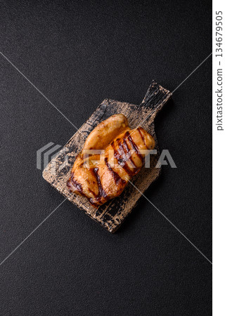Grilled boneless chicken legs baked on the barbecue for lunch. Grilled chicken as a background Grilled boneless chicken legs baked on the barbecue for lunch. Grilled chicken as a background 134679505