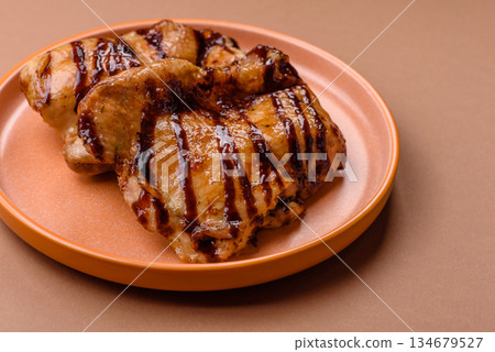 Grilled boneless chicken legs baked on the barbecue for lunch. Grilled chicken as a background 134679527