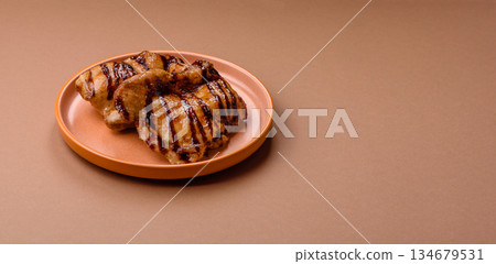 Grilled boneless chicken legs baked on the barbecue for lunch. Grilled chicken as a background Grilled boneless chicken legs baked on the barbecue for lunch. Grilled chicken as a background 134679531