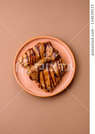Grilled boneless chicken legs baked on the barbecue for lunch. Grilled chicken as a background 134679533
