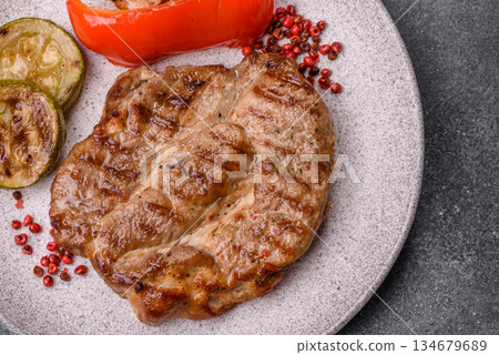 Grilled beef or pork steak, healthy restaurant food for lunch. Barbecue steak as a background Grilled beef or pork steak, healthy restaurant food for lunch. Barbecue steak as a background 134679689