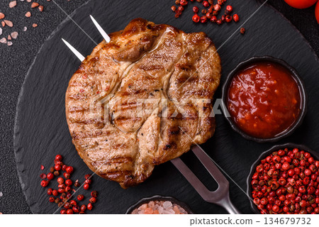 Grilled beef or pork steak, healthy restaurant food for lunch. Barbecue steak as a background Grilled beef or pork steak, healthy restaurant food for lunch. Barbecue steak as a background 134679732