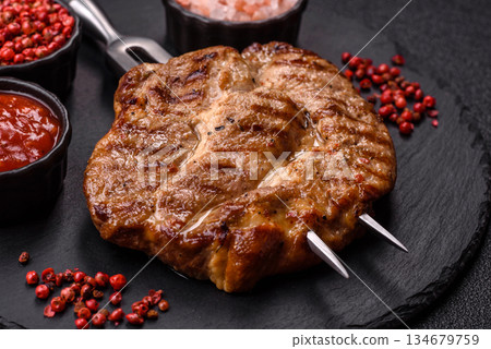 Grilled beef or pork steak, healthy restaurant food for lunch. Barbecue steak as a background Grilled beef or pork steak, healthy restaurant food for lunch. Barbecue steak as a background 134679759