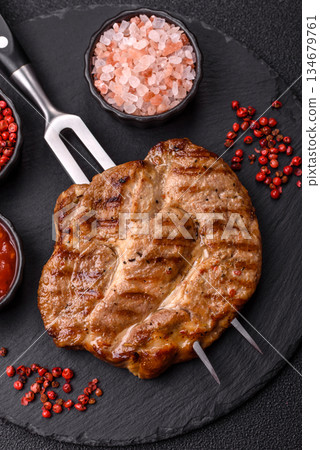 Grilled beef or pork steak, healthy restaurant food for lunch. Barbecue steak as a background Grilled beef or pork steak, healthy restaurant food for lunch. Barbecue steak as a background 134679761