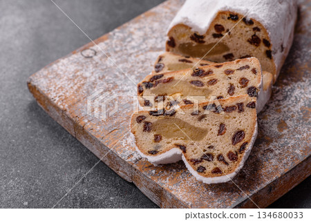 Stollen, a German Christmas pastry for the winter holidays. Stollen as a food background Stollen, a German Christmas pastry for the winter holidays. Stollen as a food background 134680033