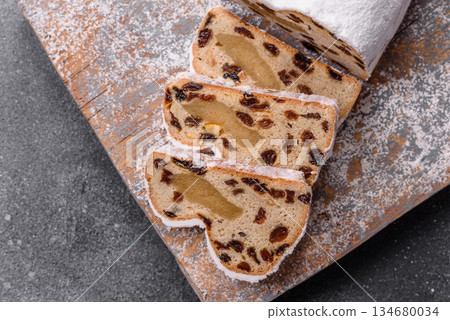 Stollen, a German Christmas pastry for the winter holidays. Stollen as a food background Stollen, a German Christmas pastry for the winter holidays. Stollen as a food background 134680034