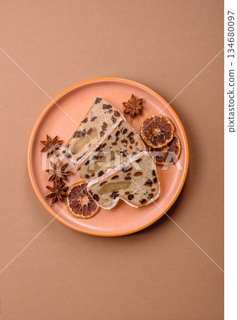 Stollen, a German Christmas pastry for the winter holidays. Stollen as a food background Stollen, a German Christmas pastry for the winter holidays. Stollen as a food background 134680097