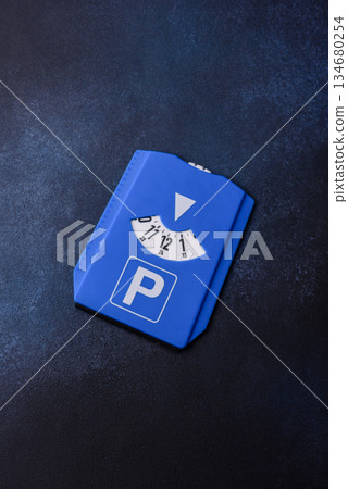 A parking disc, permit, or ticket for measuring time and paying municipal services. A parking disc A parking disc, permit, or ticket for measuring time and paying municipal services. A parking disc 134680254