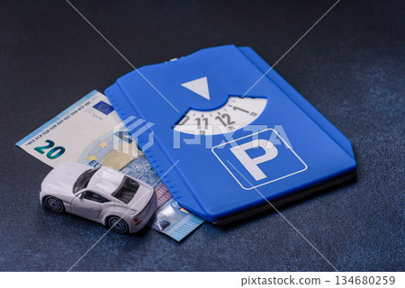 A parking disc, permit, or ticket for measuring time and paying municipal services. A parking disc 134680259