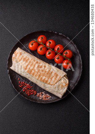 Shawarma with chicken or beef, tortilla roll, and vegetables. Shawarma with meat 134680438