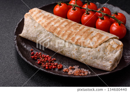 Shawarma with chicken or beef, tortilla roll, and vegetables. Shawarma with meat Shawarma with chicken or beef, tortilla roll, and vegetables. Shawarma with meat 134680440