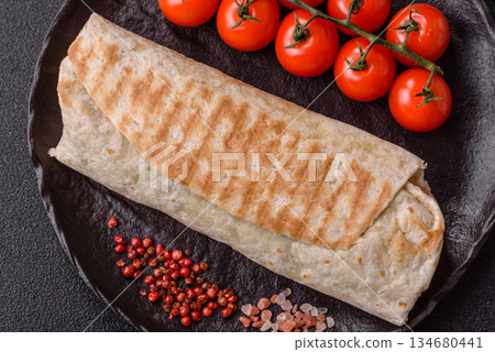 Shawarma with chicken or beef, tortilla roll, and vegetables. Shawarma with meat 134680441