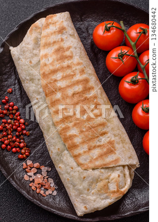 Shawarma with chicken or beef, tortilla roll, and vegetables. Shawarma with meat 134680442