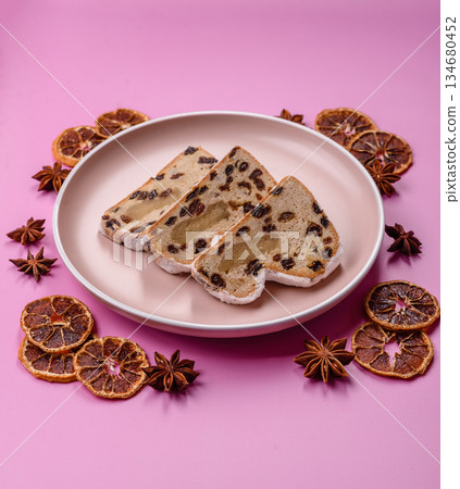 Stollen, a German Christmas pastry for the winter holidays. Stollen as a food background Stollen, a German Christmas pastry for the winter holidays. Stollen as a food background 134680452