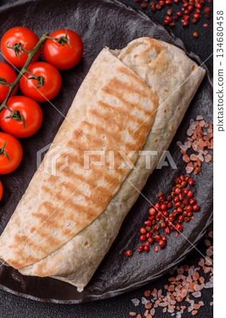 Shawarma with chicken or beef, tortilla roll, and vegetables. Shawarma with meat 134680458