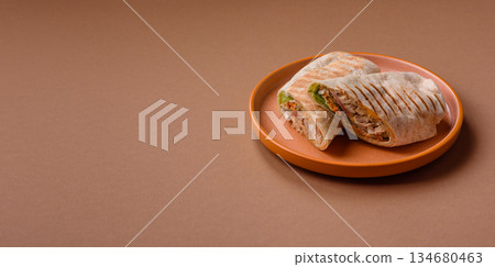 Shawarma with chicken or beef, tortilla roll, and vegetables. Shawarma with meat Shawarma with chicken or beef, tortilla roll, and vegetables. Shawarma with meat 134680463