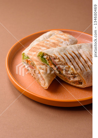 Shawarma with chicken or beef, tortilla roll, and vegetables. Shawarma with meat Shawarma with chicken or beef, tortilla roll, and vegetables. Shawarma with meat 134680469