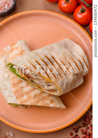 Shawarma with chicken or beef, tortilla roll, and vegetables. Shawarma with meat Shawarma with chicken or beef, tortilla roll, and vegetables. Shawarma with meat 134680472