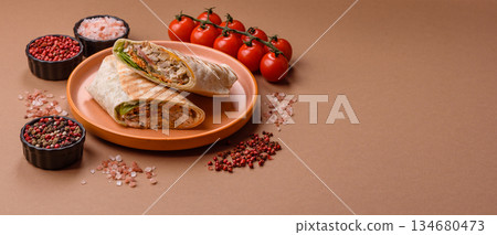 Shawarma with chicken or beef, tortilla roll, and vegetables. Shawarma with meat 134680473