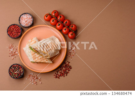 Shawarma with chicken or beef, tortilla roll, and vegetables. Shawarma with meat Shawarma with chicken or beef, tortilla roll, and vegetables. Shawarma with meat 134680474