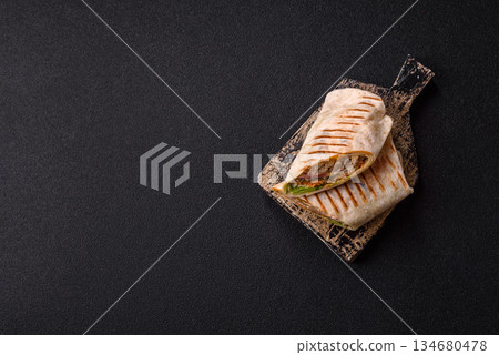 Shawarma with chicken or beef, tortilla roll, and vegetables. Shawarma with meat Shawarma with chicken or beef, tortilla roll, and vegetables. Shawarma with meat 134680478