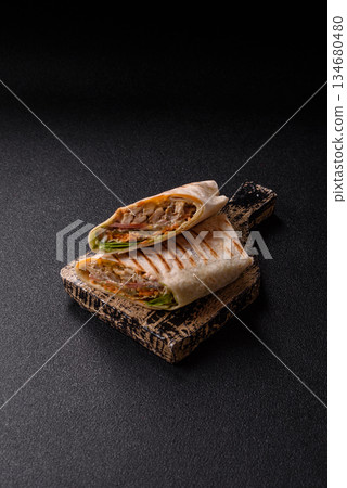 Shawarma with chicken or beef, tortilla roll, and vegetables. Shawarma with meat Shawarma with chicken or beef, tortilla roll, and vegetables. Shawarma with meat 134680480