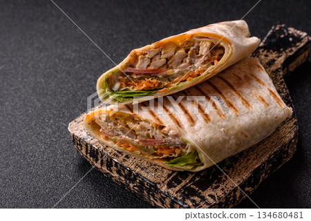 Shawarma with chicken or beef, tortilla roll, and vegetables. Shawarma with meat 134680481
