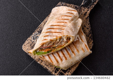 Shawarma with chicken or beef, tortilla roll, and vegetables. Shawarma with meat 134680482