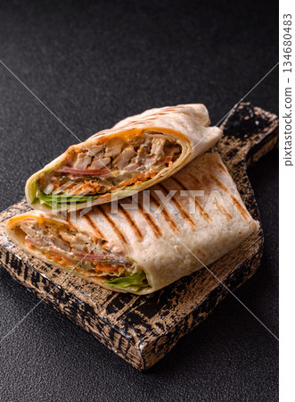 Shawarma with chicken or beef, tortilla roll, and vegetables. Shawarma with meat 134680483