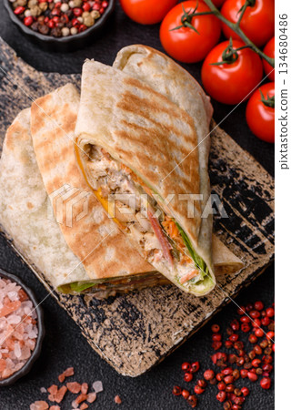 Shawarma with chicken or beef, tortilla roll, and vegetables. Shawarma with meat 134680486