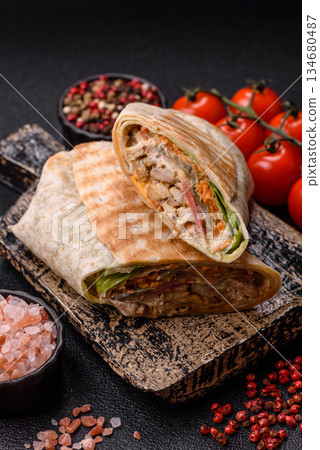 Shawarma with chicken or beef, tortilla roll, and vegetables. Shawarma with meat Shawarma with chicken or beef, tortilla roll, and vegetables. Shawarma with meat 134680487