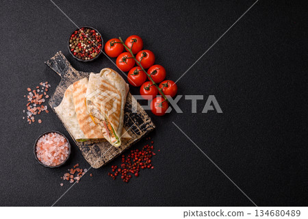 Shawarma with chicken or beef, tortilla roll, and vegetables. Shawarma with meat 134680489