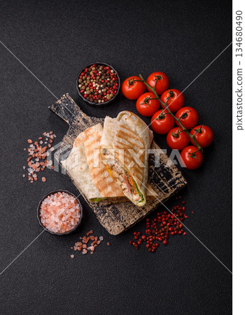 Shawarma with chicken or beef, tortilla roll, and vegetables. Shawarma with meat Shawarma with chicken or beef, tortilla roll, and vegetables. Shawarma with meat 134680490