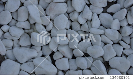 Background of white decorative pebbles on a garden flowerbed Background of white decorative pebbles on a garden flowerbed 134680501