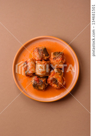 Hake fish cooked in pieces in tomato sauce, stew with peppers and carrots. Hake fish in tomato 134681501