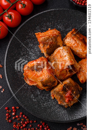 Hake fish cooked in pieces in tomato sauce, stew with peppers and carrots. Hake fish in tomato 134681519