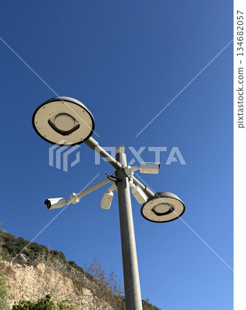 Street lights and security cameras against clear blue sky background 134682057