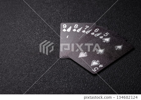 Playing card game poker in casino with chips, bets and risk. Cards and chips on black felt 134682124